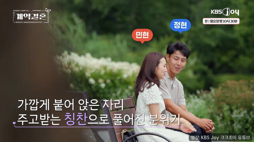 공원 벤치에 나란히 앉은 민현과 정현. 화면 왼쪽 아래에 가깝게 붙어 앉아 칭찬을 주고받는다는 자막이 있다